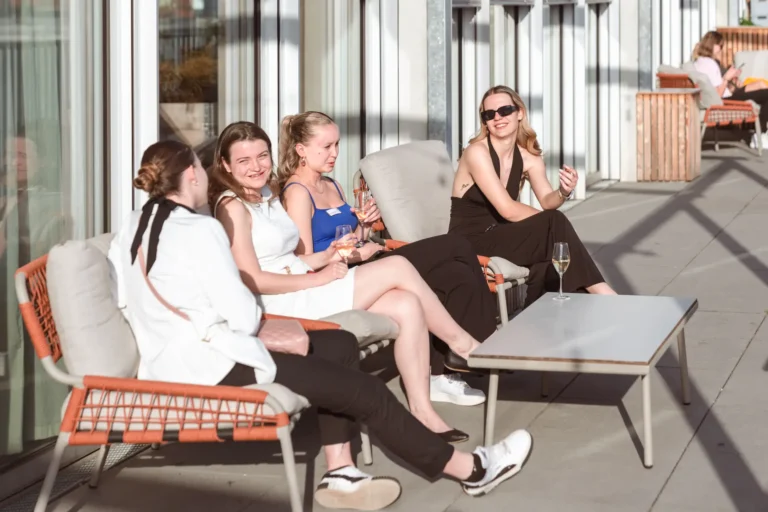 Azubis sitzen auf der Terasse beim Azubi-Event und genießen den Tag und das schöne Wetter.